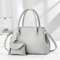 Close-up of light gray pebbled leather Boston bag set with a mini coin purse charm - Gray