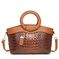Detail of two-tone brown tote bag with crocodile texture and circular handle - Earthy Yellow