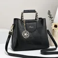 Black leather handbag with geometric patchwork and gold floral pearl pendant charm - Large / Black