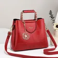 Red leather handbag with geometric stitching, gold chain handle, and camellia charm - Large / Burgundy