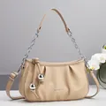 Detail of beige woven cloud bag featuring decorative metal balls and chic knotted leather - 26cm x 7cm x 15cm / Khaki