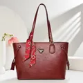 Macro detail of wine red textured tote bag featuring a decorative silk scarf and metal logo - Burgundy