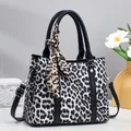 Handtasche mit Leopardenmuster, schwarzen Griffen und dekorativem Schal auf Studiohintergrund - Länge 26 cm, Breite 11,5 cm, Höhe 21 cm, Griff 14 cm / Schwarz
