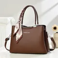 Detail of dark brown lychee leather tote bag with silk scarf and fashion text - Coffee