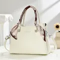Macro shot of white pebble grain leather handbag with silk scarf and silver hardware - Off White