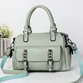 Mint green pebble leather Boston handbag with adjustable woven strap and front pocket - Green