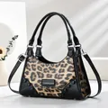 Detailansicht der Handtasche mit Leopardenmuster, schwarzen Lackbesätzen und Silbernieten - Khaki