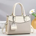 Detail of cream leather tote bag featuring woven texture and removable strap charm - Off White