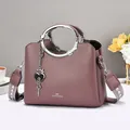 Purple lychee grain leather handbag with round metal handle and patterned strap - Purple