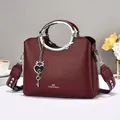 Burgundy litchi leather handbag with round silver metal handle and heart pendant - Red