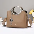 Dark brown pebble leather handbag with dual metal ring handles and woven shoulder strap - Khaki