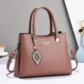 Elegant mauve leather handbag with dual handles and silver leaf pendant for women - Earthy Yellow