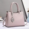 Elegant mauve leather handbag for women with pearl leaf pendant and shoulder strap - Light Pink