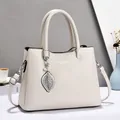 Elegant cream white faux leather handbag with pearl leaf charm and adjustable strap - White