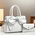 White crocodile pattern bucket bag with oversized bow and matching envelope wallet - White
