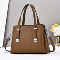 Détail du sac à main en cuir marron foncé avec motif litchi et boucles en métal argenté - Kaki foncé