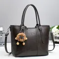 Detail of dark brown leather bucket bag with plush charm and adjustable shoulder strap - Gray