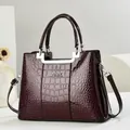 Elegante bordeauxrote Handtasche mit Krokodilprägung und silbernen Beschlägen - Kaffeebraun