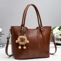 Brown faux leather bucket tote bag with plush charm and adjustable shoulder strap - Earthy Yellow