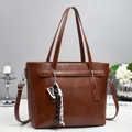 Brown faux leather tote bag with shoulder strap, decorative charms and a top handle - Earthy Yellow