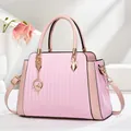 Bolso rosa minimalista con pliegues de acordeón y colgante dorado para uso cotidiano - Rosa