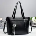 Classic black leather tote bag with woven charm and shoulder strap for commuting - Black