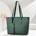 Detail of dark green tote bag featuring textured fabric and a matching small zipper pouch - Green
