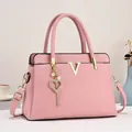 Sac cabas rose en cuir grainé avec motif V doré et pendentif cœur en perles - Rose