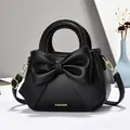 Sac à main élégant en cuir noir pour femme avec un grand nœud décoratif et détails dorés - Noir