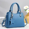 Detail der himmelblauen Tasche aus Litschileder mit silberner Hardware und Sternanhänger - Blau