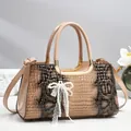 Détail du sac à main texture crocodile avec poignée dorée et pendentif nœud en perle - Kaki