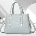 Elegante borsa a mano in pelle intrecciata blu menta con accenti dorati e tracolla - Blu