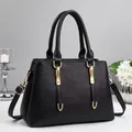 Black lychee leather handbag with gold metal hardware shown from a 45-degree angle - Black