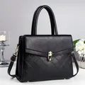 Elegant black lychee leather crossbody bag with quilted pattern and gold metal hardware - Black