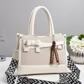 Creamy white woven leather handbag with bow detail and geometric patterned strap - Off White