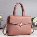 Elegant dusty rose crossbody bag with diamond quilting and gold twist lock in soft lighting - Pink
