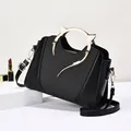 Fashionable black handbag with golden cat-ear metal handles and braided leather texture - Black