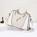 White leather handbag with golden cat-ear metal handles and woven texture side view - White