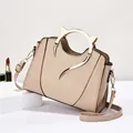 Elegante borsa a conchiglia color albicocca con manici in metallo e trama intrecciata - Kaki