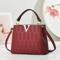 Sac à main bandoulière rouge vin élégant avec boucle V dorée et texture cuir - Rouge