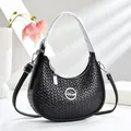 Détail du sac croissant tissé noir avec logo en métal rond et fermeture zippée - Noir