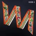 Detail van oranje zijden sjaal met bloemenpatroon en golvende lijnen op zwart decor - Oranje Stijl (X208-1)