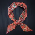 Detail of floral silk scarf tied in a knot showing smooth satin texture and orange print - Orange Red (C122-4)