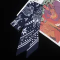 Close-up of a navy blue silk twilly scarf with intricate white floral and star patterns - C134-3 (Navy Blue)