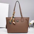 Macro detail of brown litchi leather tote with silk scarf and triangular metal plate - Brown