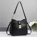 Elegant black quilted shoulder bag with gold twist lock and chain strap on minimalist background - Black