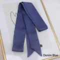Close-up of denim blue long satin ribbon scarf with texture and fabric care label - 200cm / Denim Blue