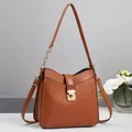 Close-up of brown PU leather shoulder bag featuring diamond quilted stitching and gold lock - Khaki/Earth Yellow