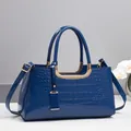 Sac Boston bleu foncé brillant à motif crocodile avec des détails dorés chic - Bleu