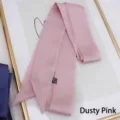 Close-up of dusky pink satin ribbon in 100% polyester with diagonal cut and care label - 200cm / Dusky Pink